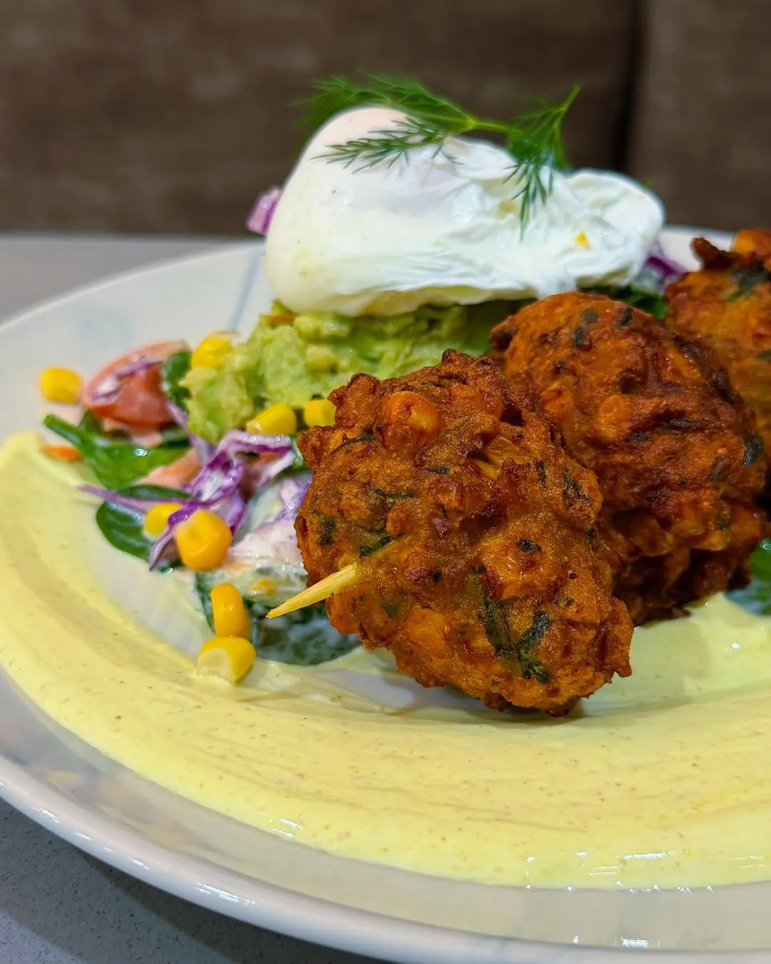 Corn and zucchini fritters with a poached egg, cucumber slaw and spiced yoghurt