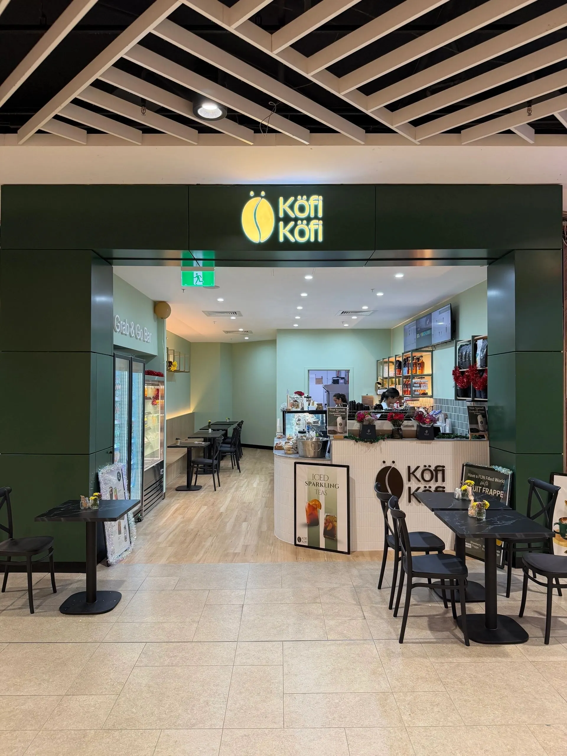 The Köfi Köfi shopfront inside HomeCo Brandon Park, with its green entrance, tables and a Grab & Go bar